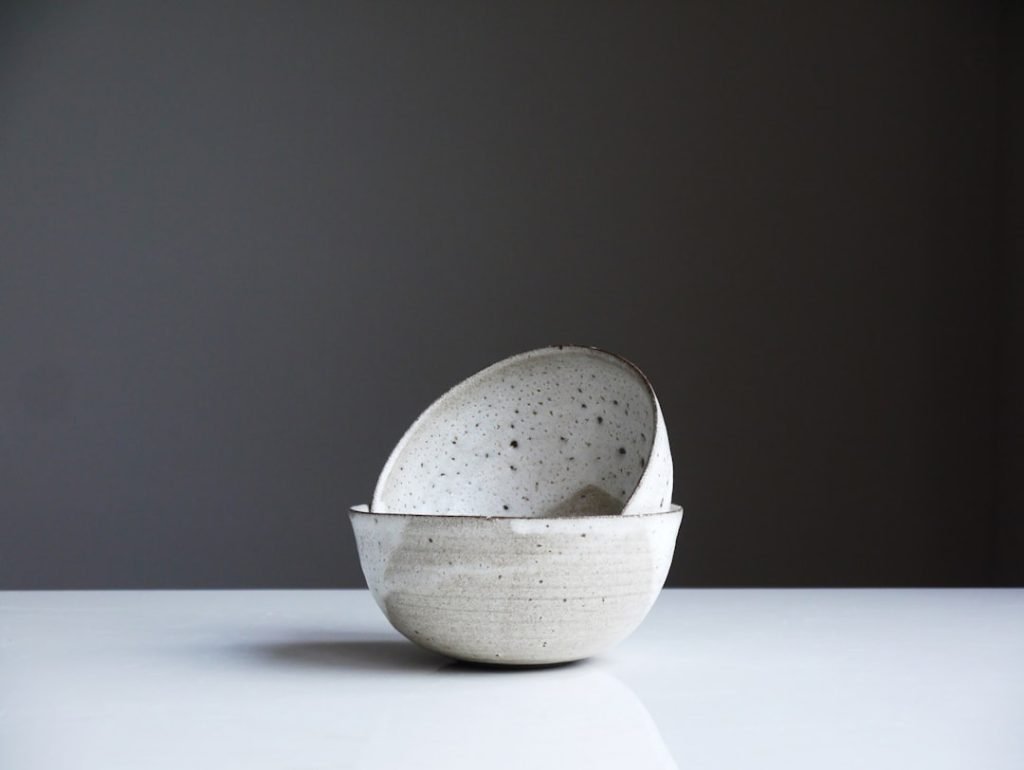 I’ve recently been invited to place my work in a gallery in Highgate, these are two bowls that form part of my table ware selection. The clay is thrown thin and these have had a full single dip of glaze, followed by two more dips to create the lines and overlap. Where they’ve overlapped there are effectively three dips, the thick glaze then having a reaction with the clay body, causing the ‘moon’ ‘volcanic’ effect… These are taken by my large lounge window on a simple white table, and are usually better when there is a soft grey light and capturing the white hues, soft shadows.