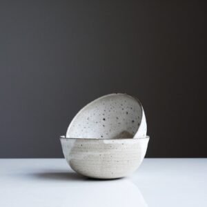 I’ve recently been invited to place my work in a gallery in Highgate, these are two bowls that form part of my table ware selection. The clay is thrown thin and these have had a full single dip of glaze, followed by two more dips to create the lines and overlap. Where they’ve overlapped there are effectively three dips, the thick glaze then having a reaction with the clay body, causing the ‘moon’ ‘volcanic’ effect… These are taken by my large lounge window on a simple white table, and are usually better when there is a soft grey light and capturing the white hues, soft shadows.